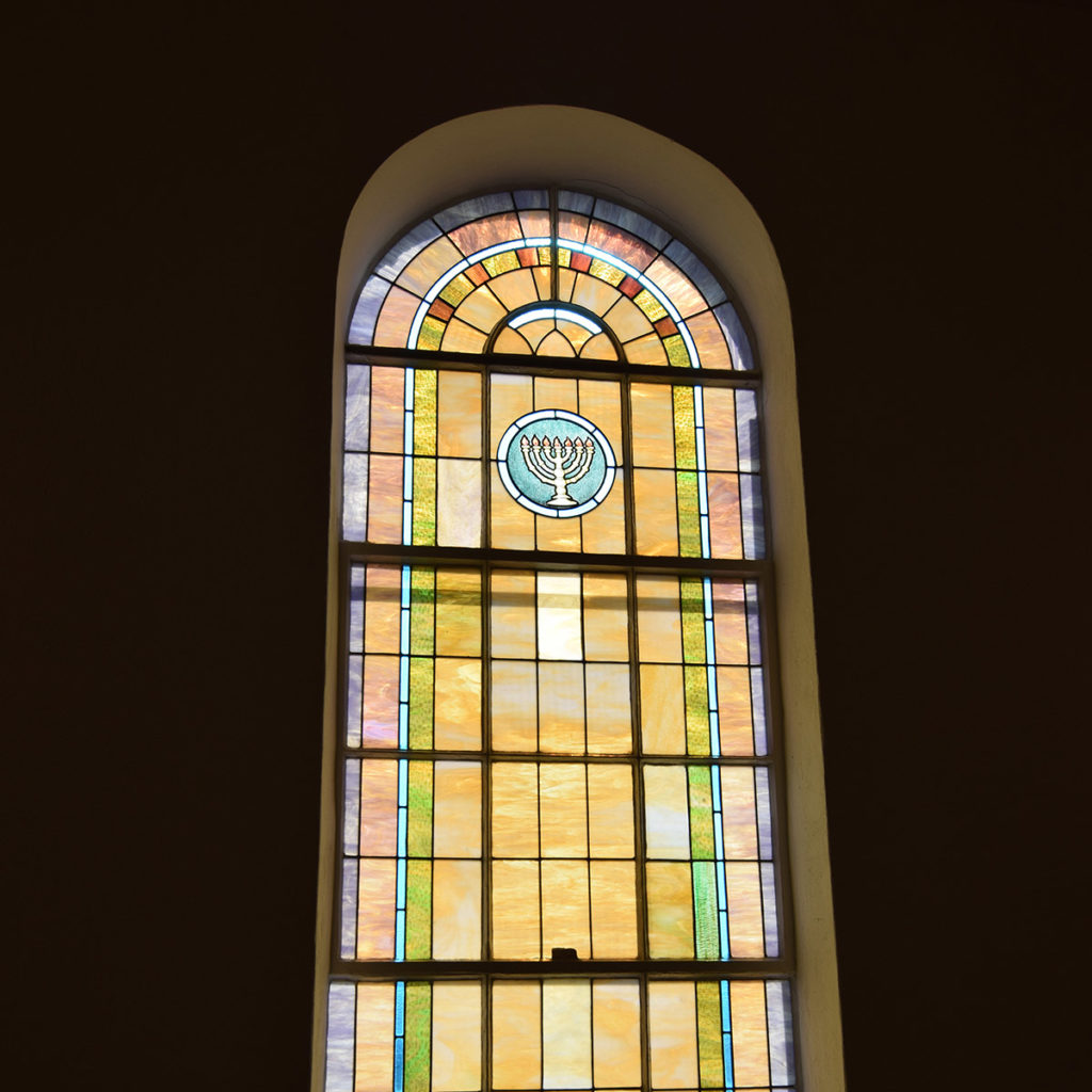 Stained glass window with a Menorah in the center